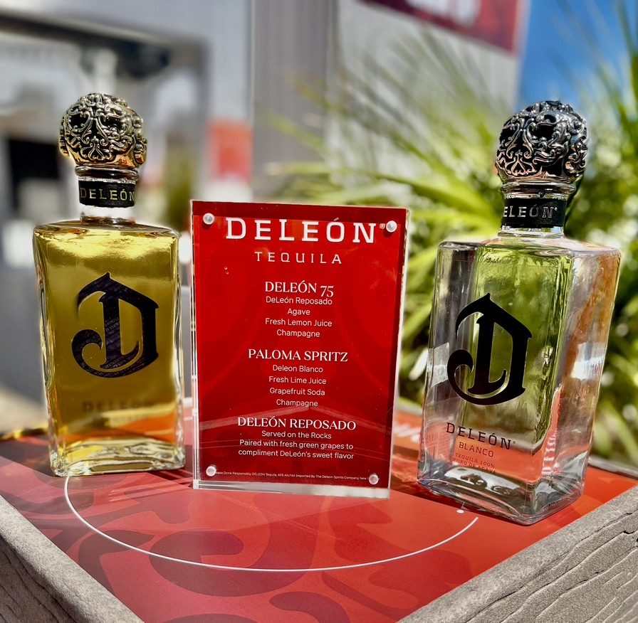 DeLeón Reposado and Blanco bottles beside a branded cocktail menu