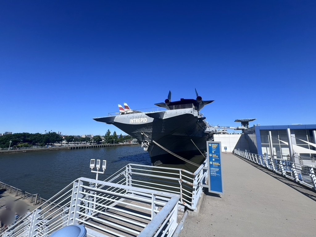 Bow of the aircraft carrier Intrepid from the pier under a clear blue sky