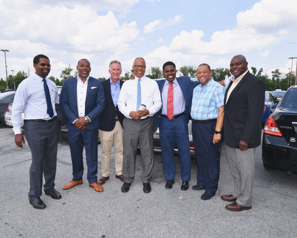 Group photo of seven men at the development site visit